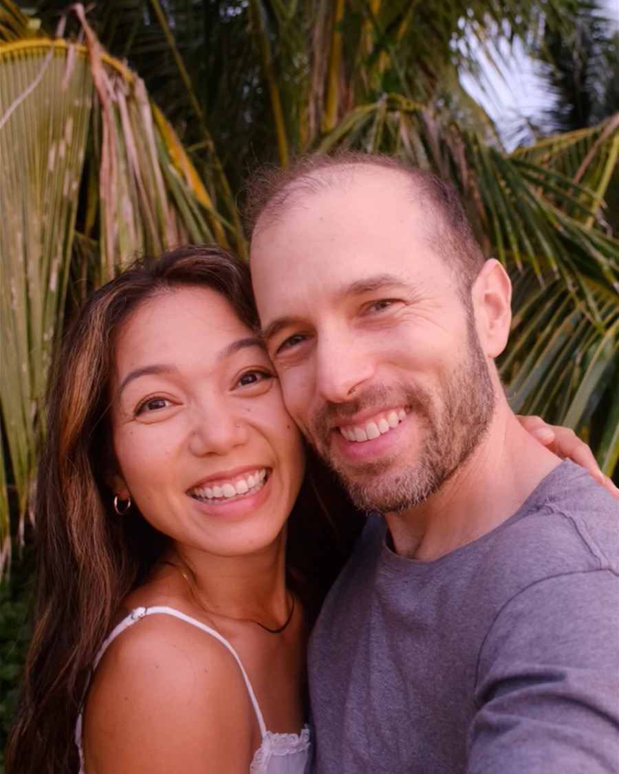 Russell and Noelani smiling cheek to cheek under the palms on Kauaʻi